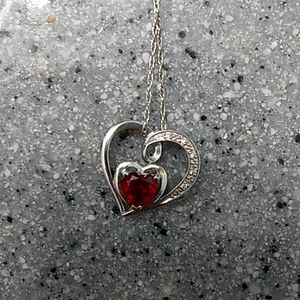 Silver necklace with red gem in the middle